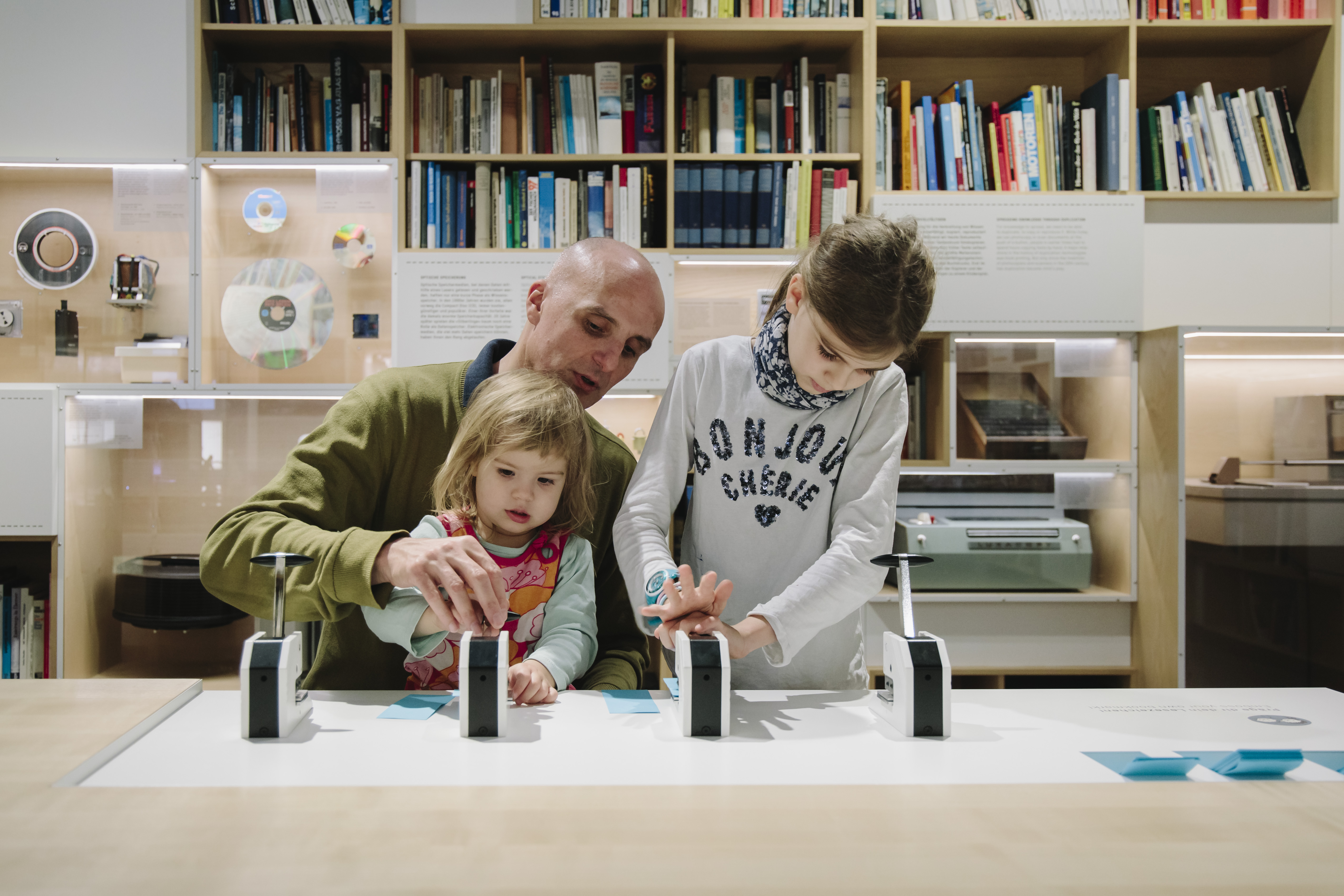 A man with two small children at a hands-on table in the Network exhibition