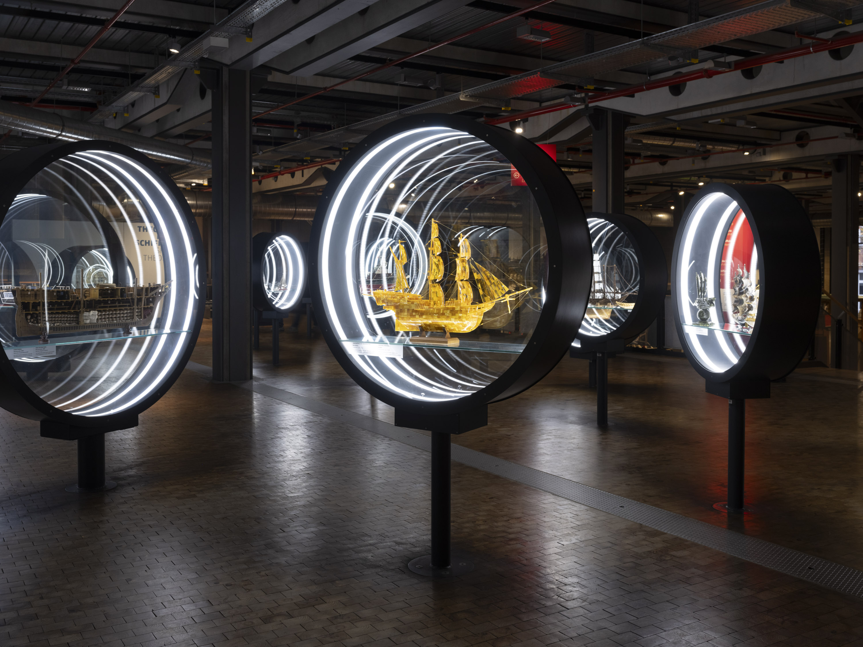 Porthole-shaped display cases containing various ship models.
