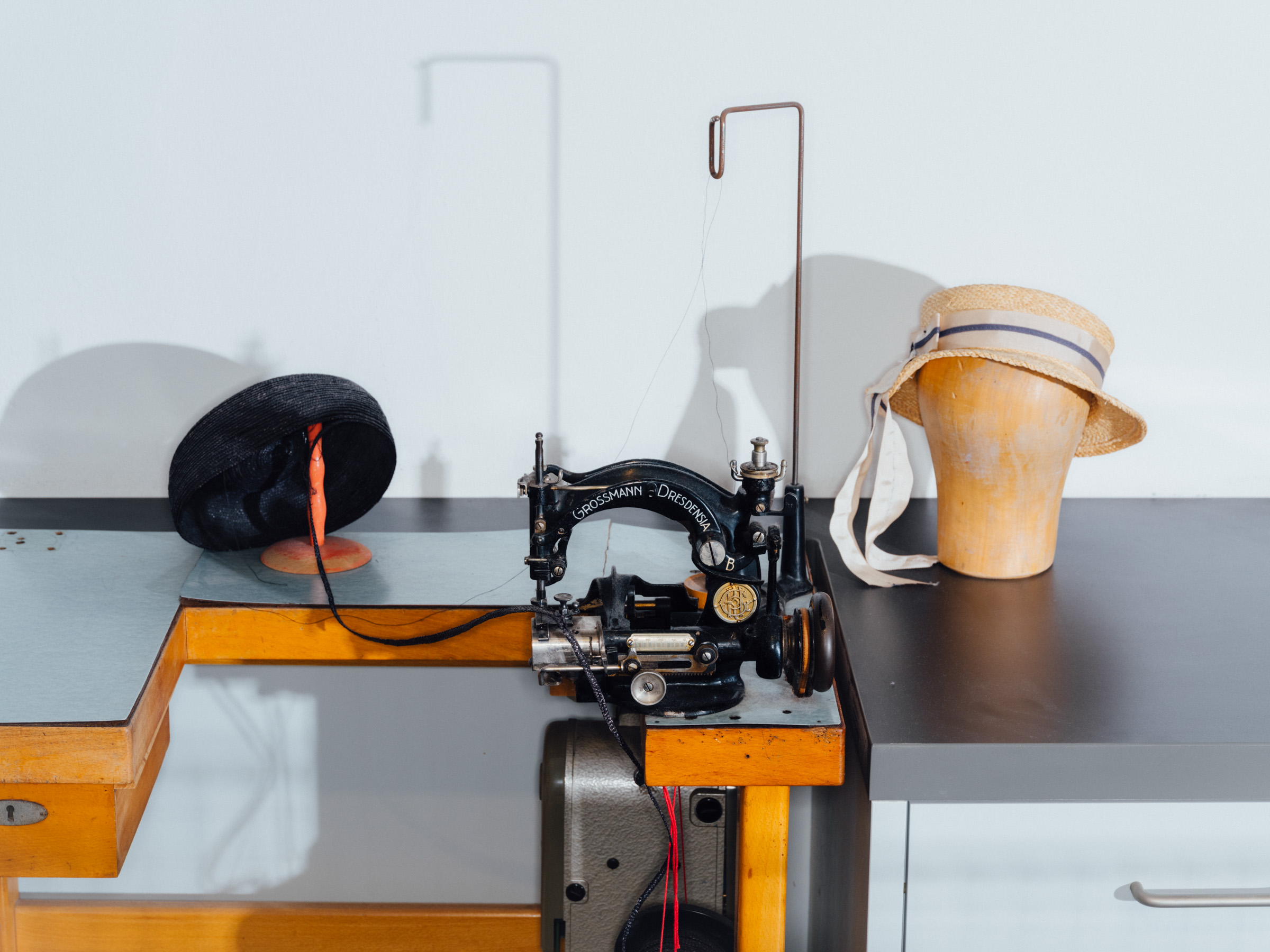 A hat-making machine next to a finished hat.