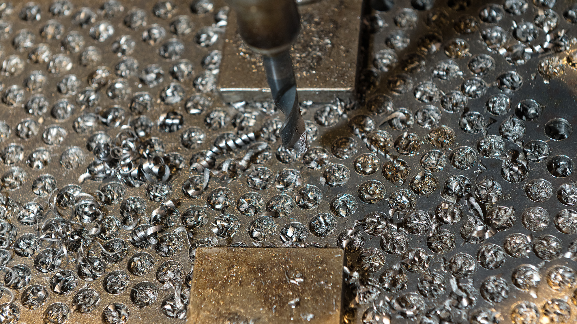 A piece of metal with circular holes milled into it