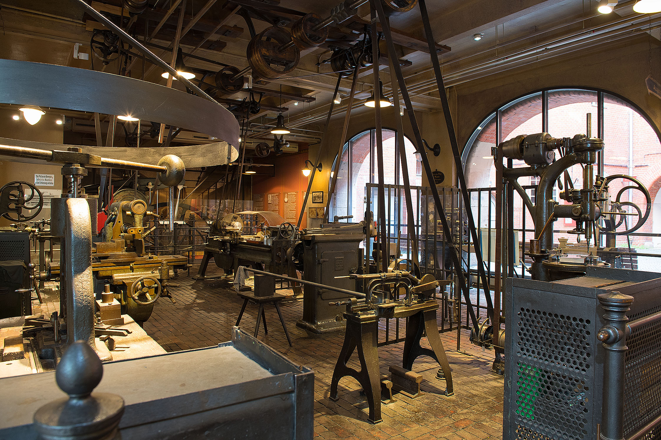 A look inside the historic workshop: Various metalworking machines are set up here. High up on the ceiling, you can see the various gears and the drive belt that power the machines via a steam engine.