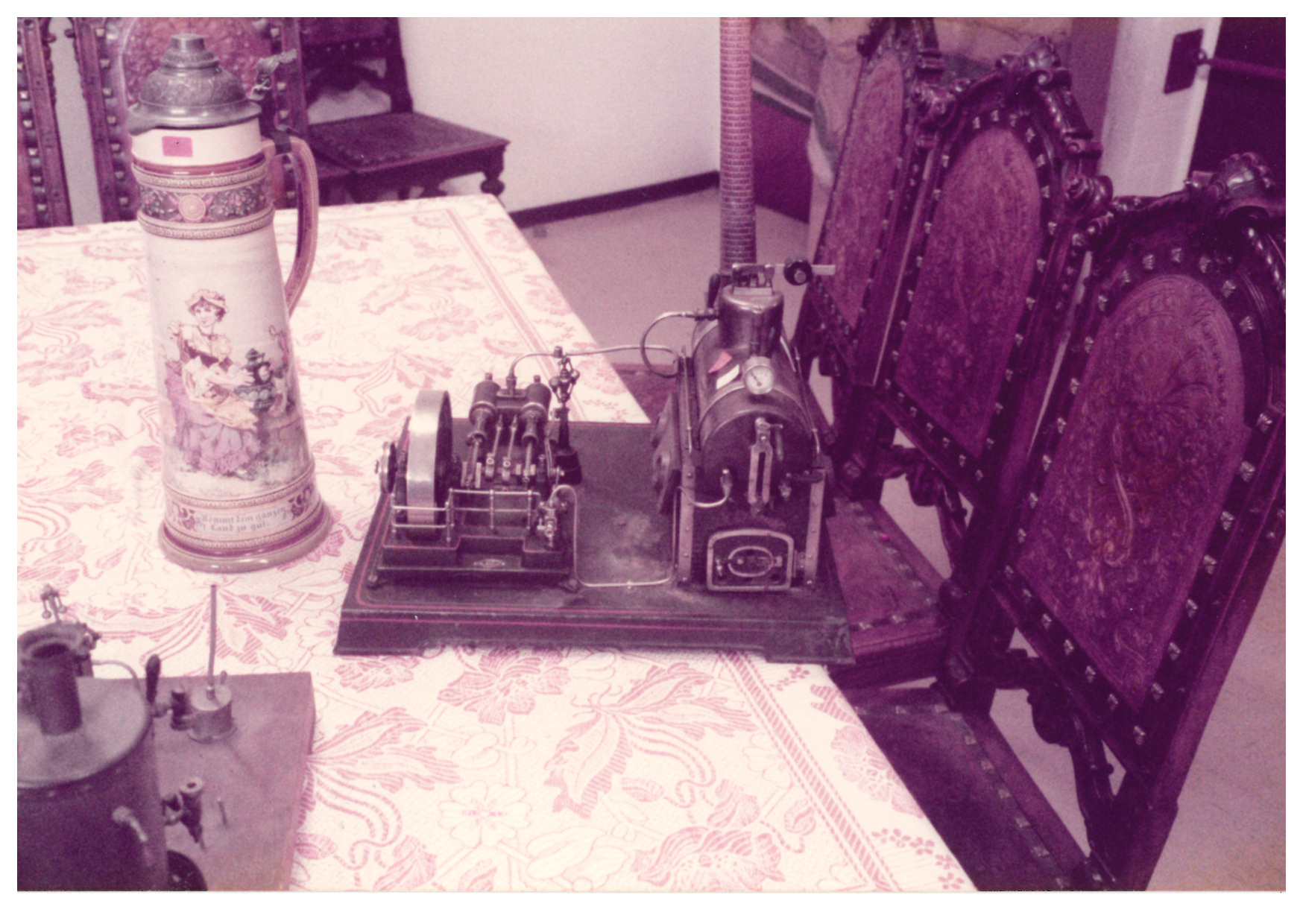 A table, several chairs, a drinking vessel, and a model steam engine in the KuA warehouse in Mühlenbeck.